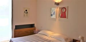 a bedroom with a bed and some pictures on the wall at Casale del Mare in Castiglioncello