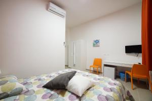una camera da letto con un letto, una scrivania e delle sedie di Affittacamere Arcobaleno a Trapani