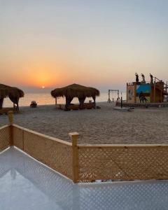 una playa con sombrillas en la arena y el océano en Al Khalil Beach Camp, en Nuweiba