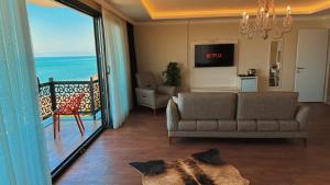 a living room with a couch and a view of the ocean at BİLİRİS HOTEL in Trabzon