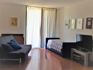 ein Wohnzimmer mit einem Sofa, einem Bett und einem TV in der Unterkunft Casale del Mare in Castiglioncello