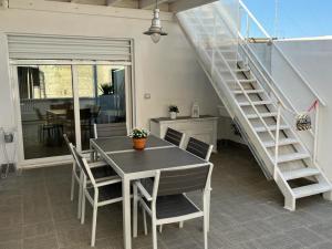 a dining room with a table and chairs and a staircase at Suite Sui Tetti Apartment in Bari +10 photos