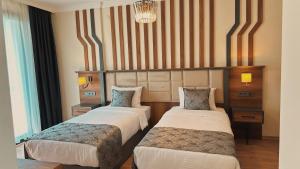 a hotel room with two beds and a chandelier at BİLİRİS HOTEL in Trabzon