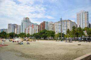 a beach with people and buildings in a city at Lindo Apartamento compacto na quadra da praia in Santos