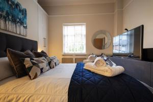 a bedroom with a bed with towels on it at Stylish Central Apartment with Parking & Lift in Bury Saint Edmunds +16 photos