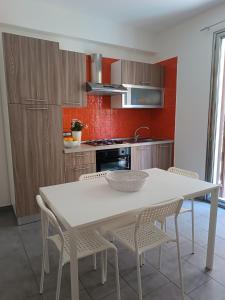 una cucina con tavolo e sedie bianchi di A' Nica a Bagheria