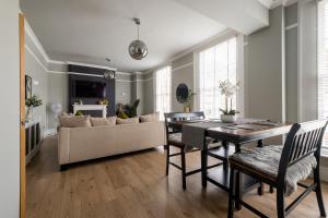 a living room with a table and a couch at Stylish Central Apartment with Parking & Lift in Bury Saint Edmunds