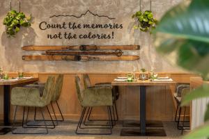 un restaurant avec deux tables et un panneau sur le mur dans l'établissement Aktiv Panoramahotel Daniel, à Sautens