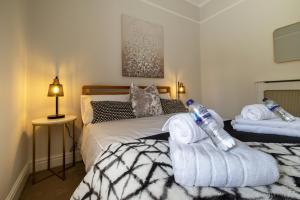 a bedroom with a bed with towels on it at Stylish Central Apartment with Parking & Lift in Bury Saint Edmunds