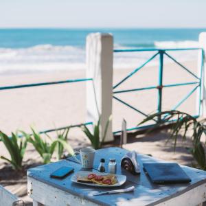 una mesa con un plato de comida en la playa en Casita de Playa BOMALU, en Las Peñitas