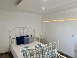 a bedroom with a white bed with blue pillows at The Dive Studio in Larnaka