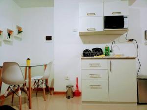 eine kleine Küche mit Tisch und Mikrowelle in der Unterkunft Hospedaje Libertador San Martín - Dpto. entero # 2 in Víctor Larco Herrera + 8 Fotos