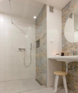 a bathroom with a shower and a sink and a mirror at Willa Kosówka - Apartamenty i pokoje in Zakopane
