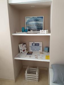 a shelf in a room with books on it at Suite Sui Tetti Apartment in Bari