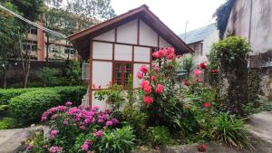 a small house with flowers in a garden at the 1959 house in Shillong