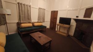 a living room with a couch and a tv at the 1959 house in Shillong
