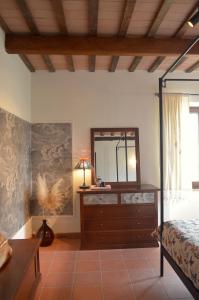 ein Schlafzimmer mit einem Bett und eine Kommode mit einem Spiegel in der Unterkunft Villa Verdicchio - B&B for winelovers in Cupramontana