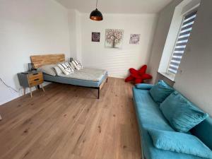 a living room with a blue couch and a bed at Apartment Mirabelle 2 in Püttlingen