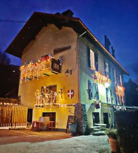 a house with christmas lights on the side of it at Hôtel Restaurant "La Petite Auberge" in Bourg-Saint-Maurice