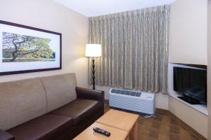 a living room with a couch and a flat screen tv at Admiral Suites - Annapolis in Annapolis