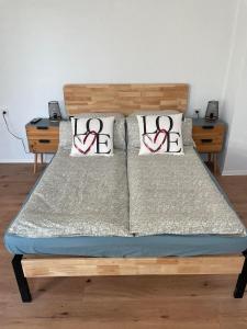 a bed with two red ribbon pillows on it at Apartment Mirabelle 2 in Püttlingen