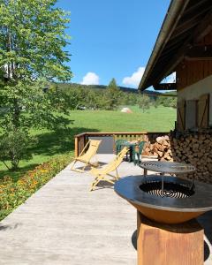 a patio with a grill and a table and chairs at le chalet de Plainpalais in Les Déserts