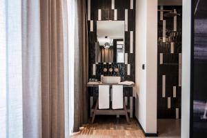 - un couloir avec une table et un miroir dans la chambre dans l'établissement Terme Preistoriche Resort & Spa, à Montegrotto Terme