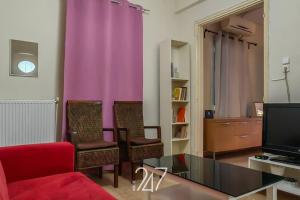 ein Wohnzimmer mit einem roten Sofa und lila Vorhängen in der Unterkunft Volos Cental House in Volos