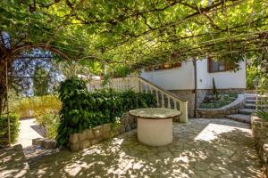 a patio with a table under a pergola at Villa The Nest in Opatija