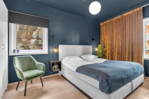 ein Schlafzimmer mit einem Bett und einem grünen Stuhl in der Unterkunft Arctic Homes - Home Living in Tromsø