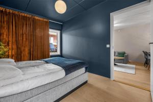 ein Schlafzimmer mit einem großen Bett mit blauen Wänden in der Unterkunft Arctic Homes - Home Living in Tromsø