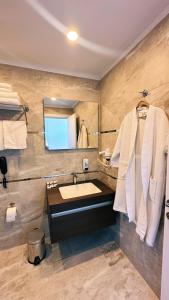 a bathroom with a sink and a mirror and towels at BİLİRİS HOTEL in Trabzon