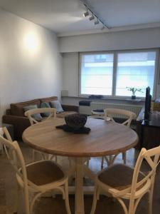 a living room with a wooden table and chairs at Duinenwachter in Knokke-Heist