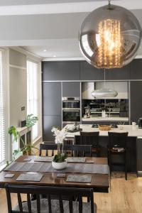 cocina y comedor con mesa y sillas en Stylish Central Apartment with Parking & Lift, en Bury Saint Edmunds