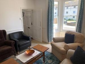 a living room with two chairs and a table at Vine Cottage - Sandgate in Sandgate