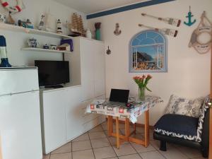 a kitchen with a table with a laptop on it at PASSIONE MARINARA-Trilocale con ARIA CONDIZIONATA e Parcheggio a Marcelli in Numana +9 photos