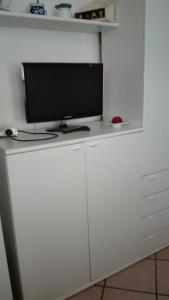 a tv sitting on top of a white cabinet at PASSIONE MARINARA-Trilocale con ARIA CONDIZIONATA e Parcheggio a Marcelli in Numana