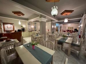 a dining room with tables and chairs in a restaurant at Hotel Ioni in Paralia Katerinis