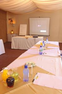 a group of tables with bottles and glasses on them at Hotel Portao Diaz in Mossel Bay