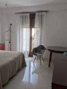 1 dormitorio con 1 cama, 1 silla y 1 mesa en CasaBaena Rafi en Baena