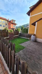 ein Holzzaun vor einem Haus in der Unterkunft Preciosa casa con jardín en Nueva de Llanes in Nueva de Llanes