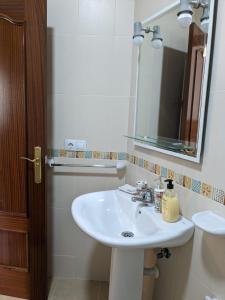 y baño con lavabo blanco y espejo. en CasaBaena Rafi en Baena
