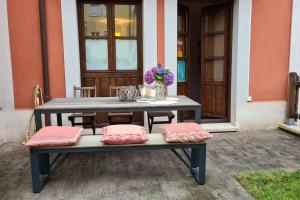 ein Picknicktisch mit zwei Kissen und Blumen darauf in der Unterkunft Preciosa casa con jardín en Nueva de Llanes in Nueva de Llanes + 3 Fotos