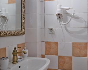 een badkamer met een wastafel en een spiegel bij comfort apartment in Tripolis