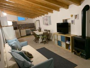 ein Wohnzimmer mit einem Sofa, einem TV und einem Tisch in der Unterkunft Antico casale Sofia in Sortino