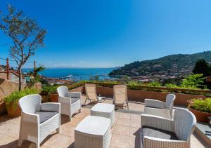 a group of chairs and tables on a patio at Super Terrace in Porto Santo Stefano