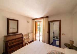 a bedroom with a bed and a dresser and a mirror at Super Terrace in Porto Santo Stefano