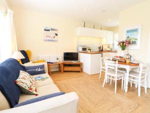 ein Wohnzimmer und eine Küche mit einem Sofa und einem Tisch in der Unterkunft The Cranny in Norwich