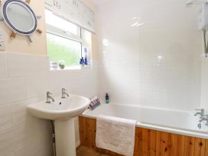 ein Badezimmer mit einem Waschbecken, einer Badewanne und einem Spiegel in der Unterkunft The Cranny in Norwich