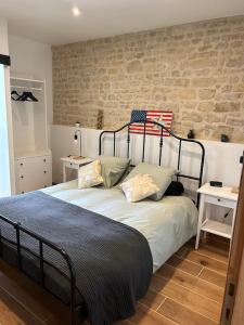 a bed in a bedroom with a brick wall at CHÂTEAU DE FRANQUETOT & D Day Collins Museum in Sainte-Mère-Église